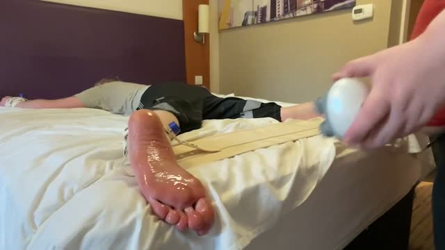 Oiled feet tickled with massager