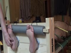 Naked bear tickled in stocks and on a rack