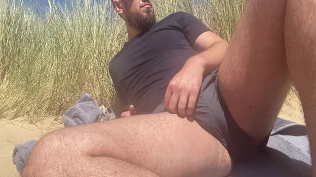Bearded guy cumming on public beach